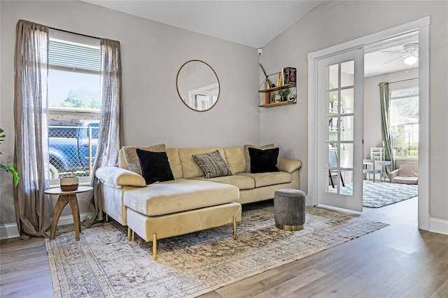 living room featuring a ceiling fan, lofted ceiling, wood finished floors, and baseboards