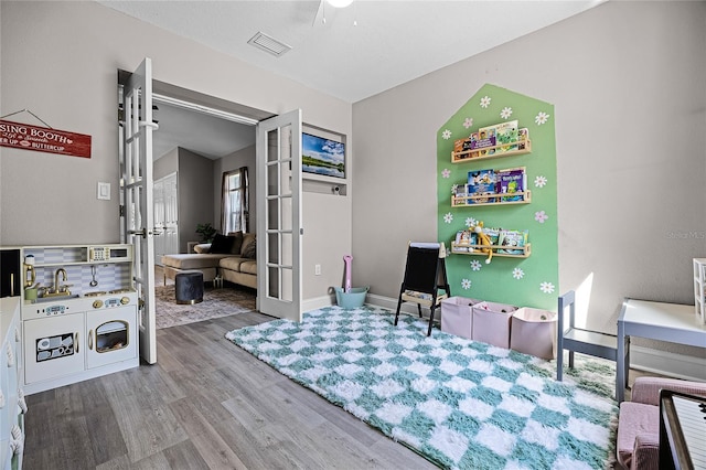 playroom with visible vents, french doors, baseboards, and wood finished floors