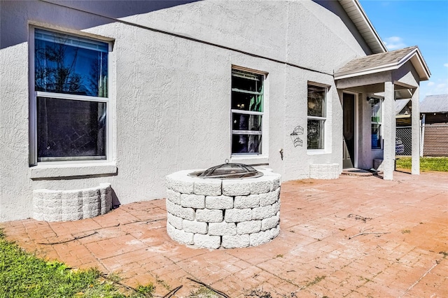 view of patio with a fire pit and fence