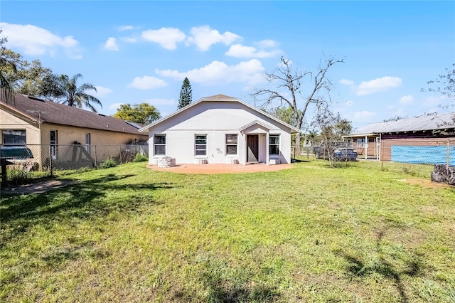 back of property featuring a yard, a fenced backyard, and stucco siding