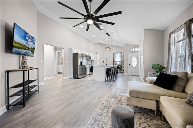 1613 N Lakewood Ave, Ocoee, FL 34761 - living room featuring baseboards, light wood-type flooring, a ceiling fan, recessed lighting, and high vaulted ceiling