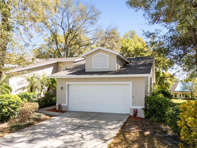 view of front of house featuring an attached garage, roof with shingles, concrete driveway, and stucco siding