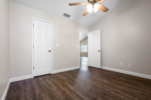 unfurnished bedroom featuring lofted ceiling, visible vents, dark wood-type flooring, a ceiling fan, and baseboards