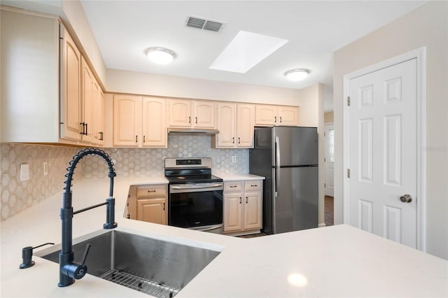 kitchen with tasteful backsplash, light countertops, visible vents, appliances with stainless steel finishes, and a sink