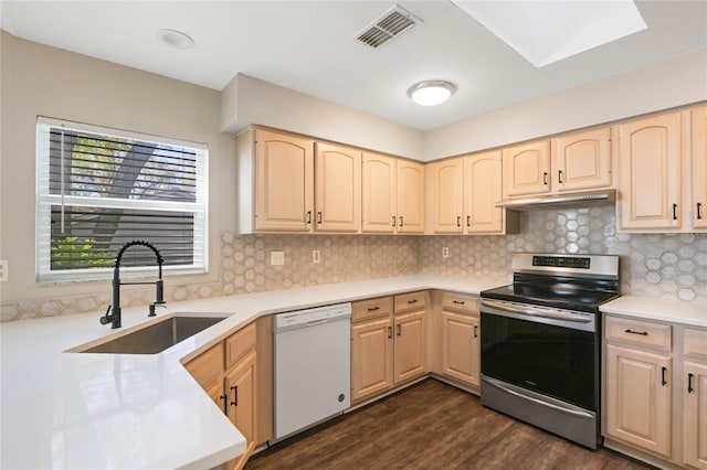 kitchen featuring electric range, visible vents, white dishwasher, under cabinet range hood, and a sink