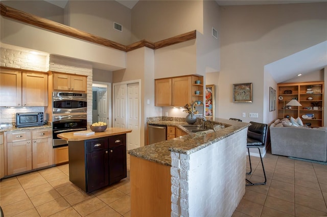 kitchen with visible vents, a sink, light tile patterned floors, stainless steel appliances, and open shelves