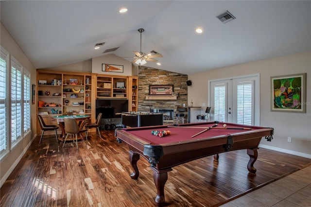 rec room featuring visible vents, lofted ceiling, a fireplace, wood finished floors, and a ceiling fan