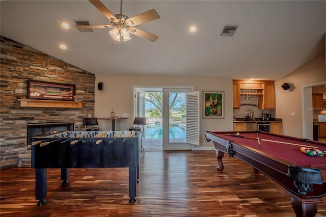 recreation room with a ceiling fan, visible vents, dark wood finished floors, lofted ceiling, and a bar