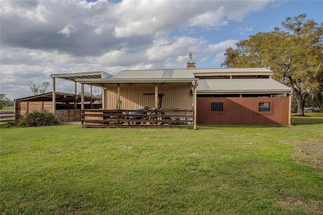 rear view of house featuring an exterior structure, metal roof, and an outdoor structure