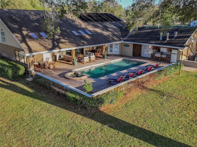 pool with french doors, a patio, and a yard