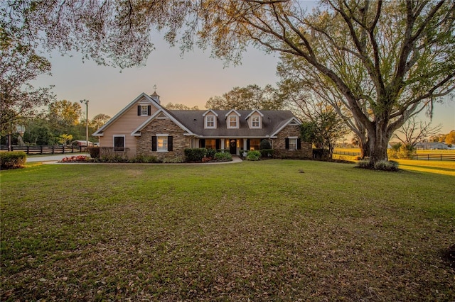 31707 Orange St, Sorrento, FL 32776 - view of front facade featuring a chimney, a front lawn, fence, and stone siding