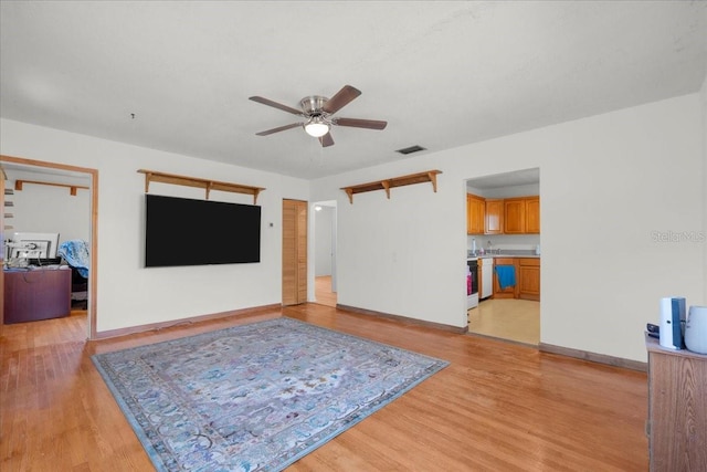 living area with ceiling fan, baseboards, visible vents, and light wood-style floors