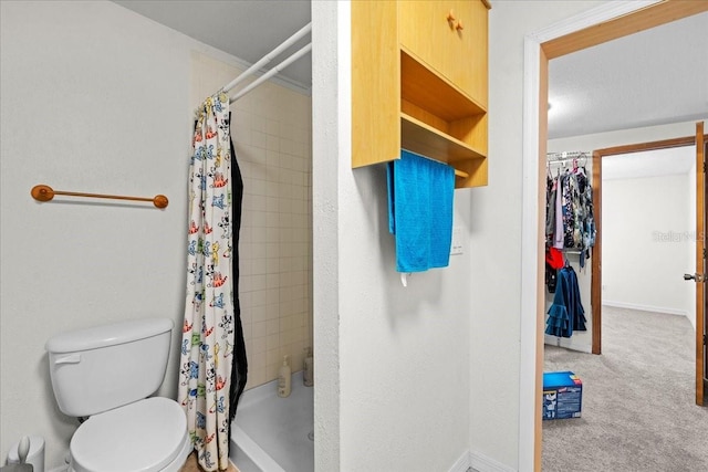 bathroom with a stall shower, baseboards, and toilet