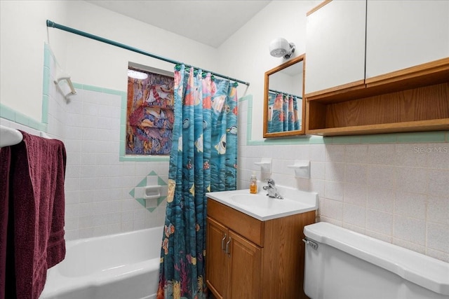 full bathroom featuring toilet, a wainscoted wall, vanity, tile walls, and shower / tub combo with curtain