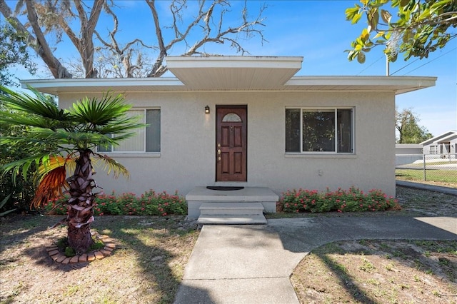 view of front of home featuring fence and stucco siding