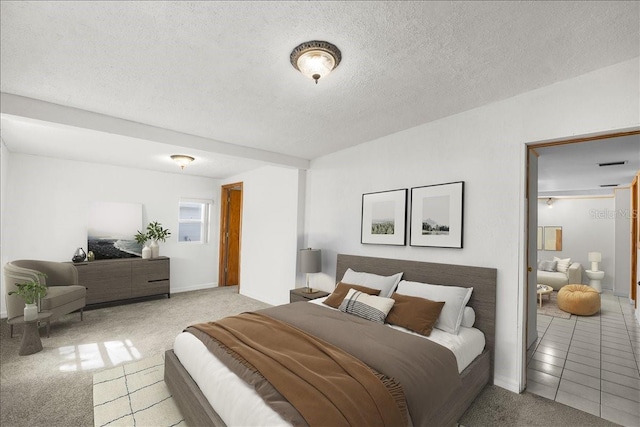 bedroom with a textured ceiling, light tile patterned floors, and light colored carpet