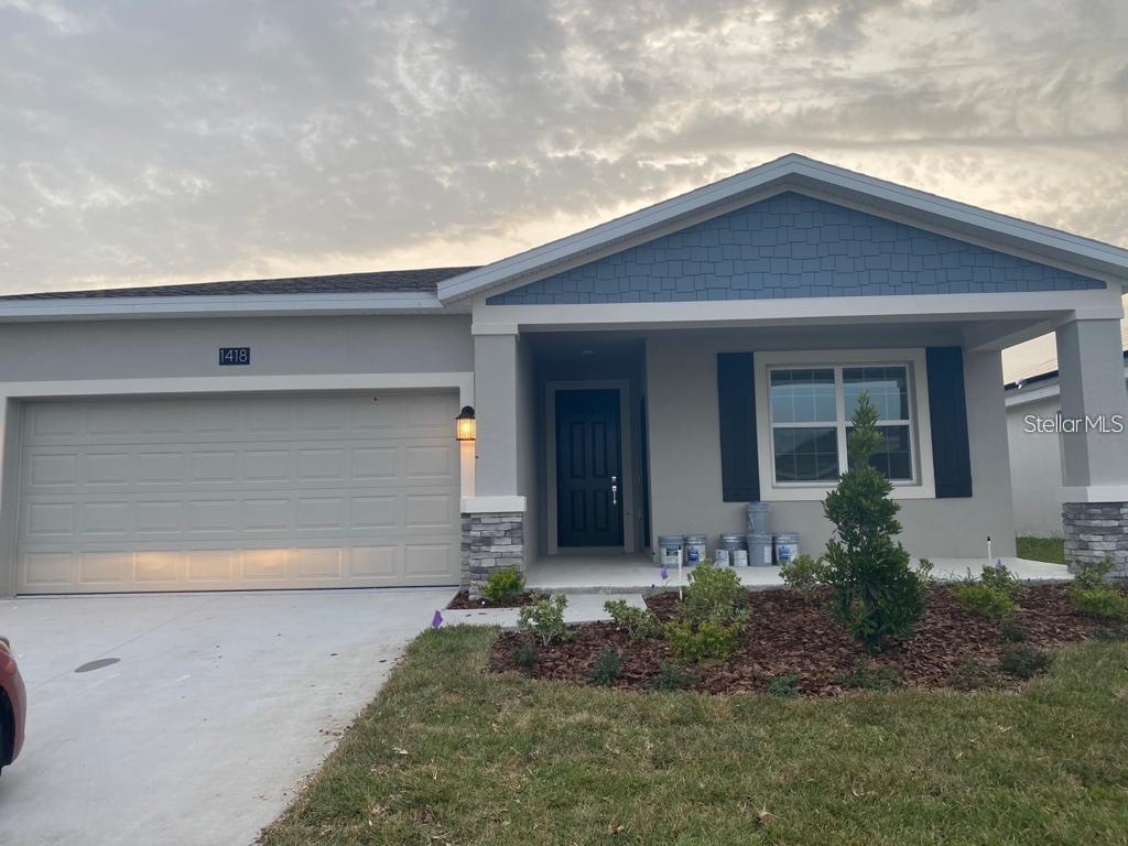 view of front of property featuring an attached garage, covered porch, driveway, and stucco siding