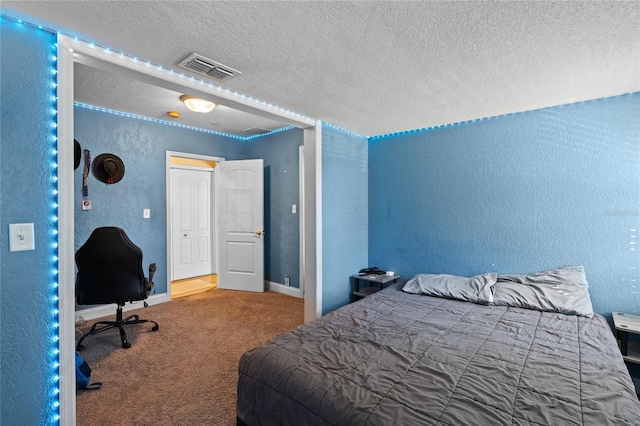 carpeted bedroom featuring a textured ceiling, a textured wall, visible vents, and baseboards