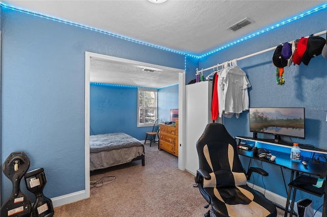 carpeted bedroom with baseboards, visible vents, a textured ceiling, and a textured wall