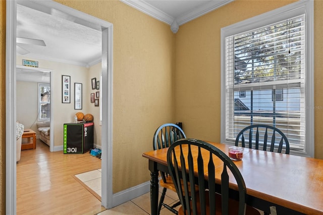 dining area featuring light wood-type flooring, baseboards, and crown molding