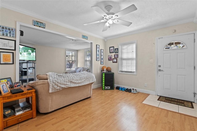 living room featuring a textured ceiling, ornamental molding, and wood finished floors