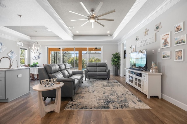 living area featuring a raised ceiling, visible vents, and wood finished floors