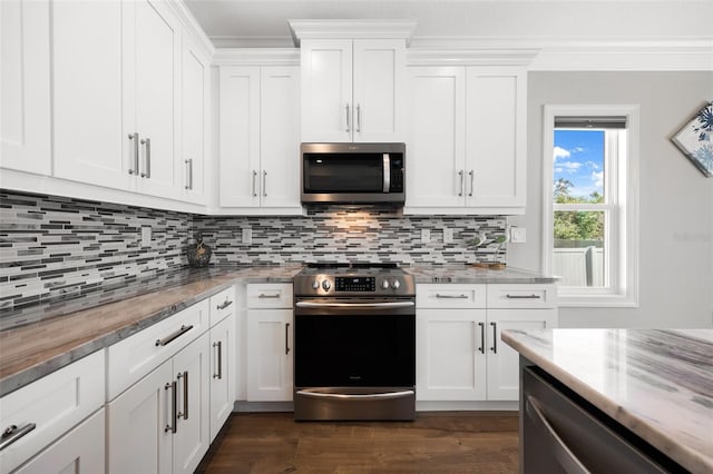 kitchen featuring appliances with stainless steel finishes, white cabinets, decorative backsplash, and light stone countertops