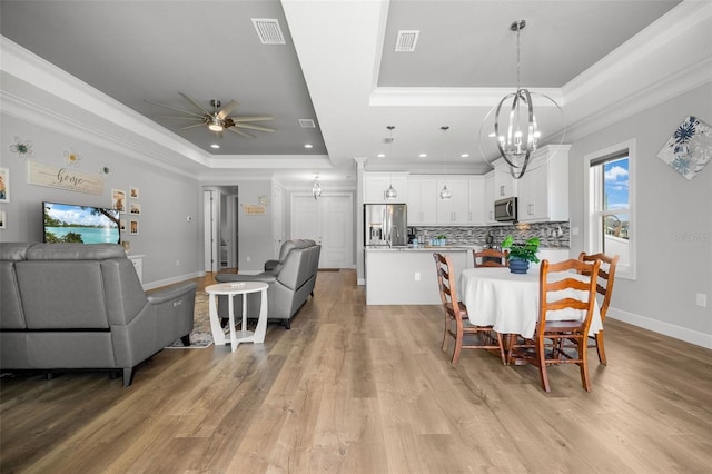 dining room featuring visible vents, a raised ceiling, and ornamental molding