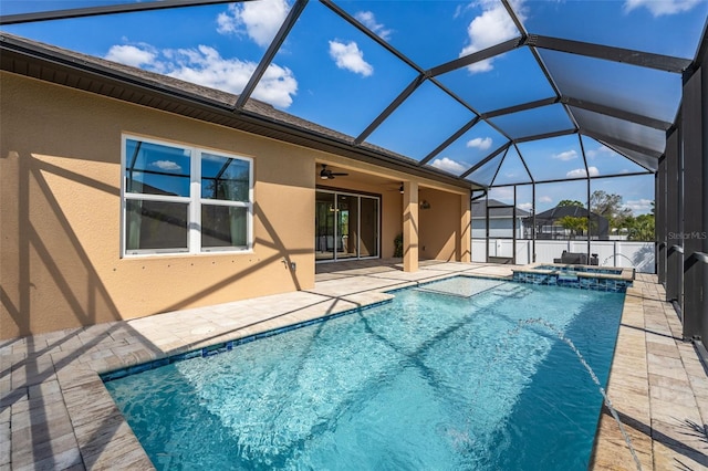 view of pool with a patio area, a pool with connected hot tub, glass enclosure, and a ceiling fan