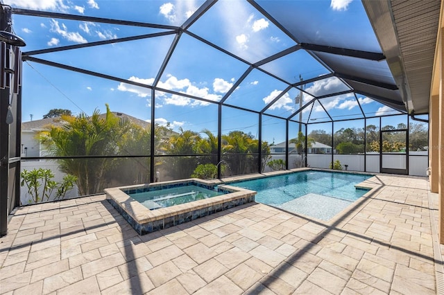 view of pool featuring a patio area, a pool with connected hot tub, and glass enclosure