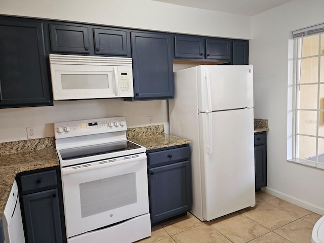 kitchen featuring white appliances, blue cabinetry, light tile patterned flooring, and baseboards