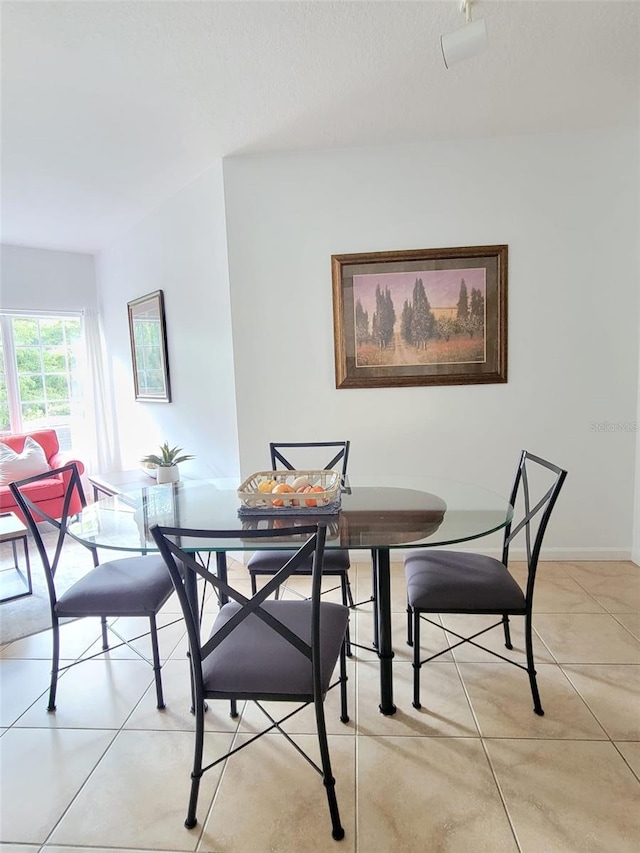 dining area with light tile patterned flooring and baseboards