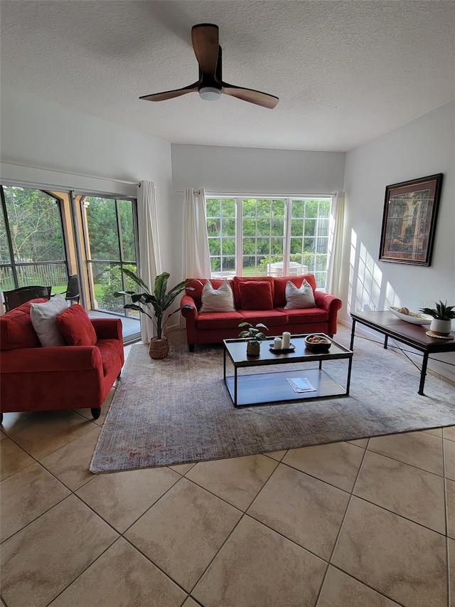 tiled living room with a wealth of natural light, a textured ceiling, and a ceiling fan