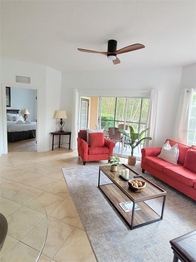 living area with light tile patterned floors, visible vents, and a ceiling fan