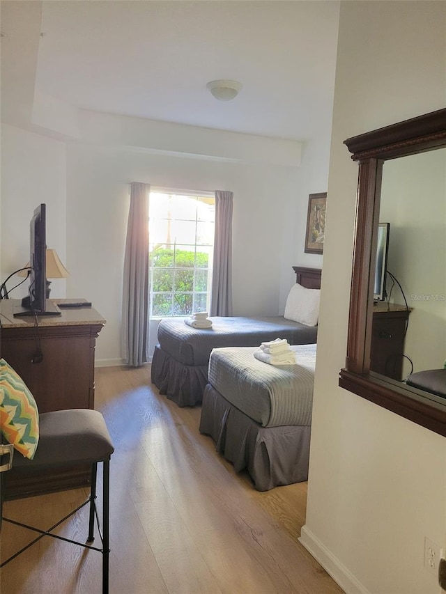 bedroom featuring baseboards and wood finished floors