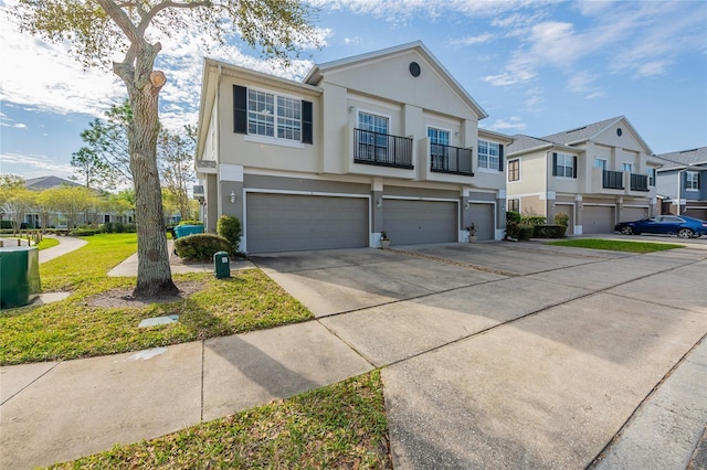 view of front of house with a residential view, stucco siding, driveway, a balcony, and an attached garage