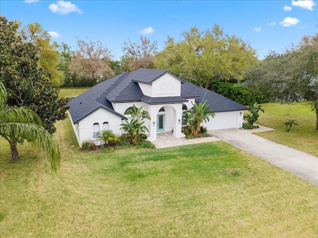 view of front of property with concrete driveway, a front lawn, an attached garage, and stucco siding