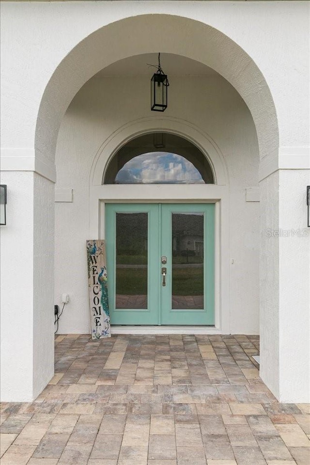 property entrance featuring french doors and stucco siding