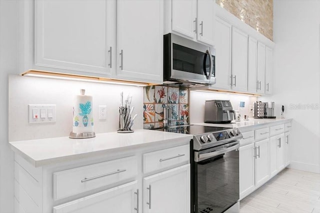 kitchen with white cabinets, stainless steel appliances, and light countertops