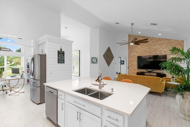 kitchen featuring visible vents, white cabinets, stainless steel appliances, high vaulted ceiling, and a sink