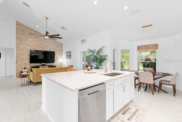 kitchen with visible vents, white cabinets, lofted ceiling, stainless steel dishwasher, and a sink