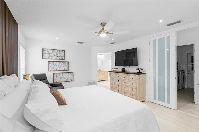 bedroom featuring light wood-style floors, visible vents, a ceiling fan, and washing machine and clothes dryer