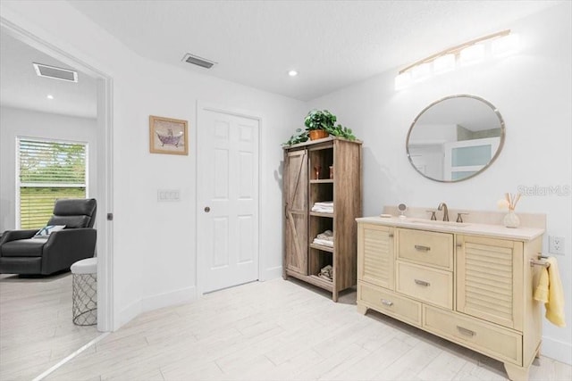 bathroom with wood finished floors, vanity, visible vents, and recessed lighting