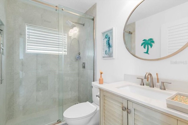 full bath featuring a stall shower, vanity, and toilet