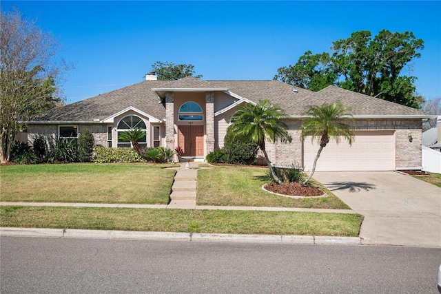 view of front facade featuring brick siding, a garage, concrete driveway, and a front yard