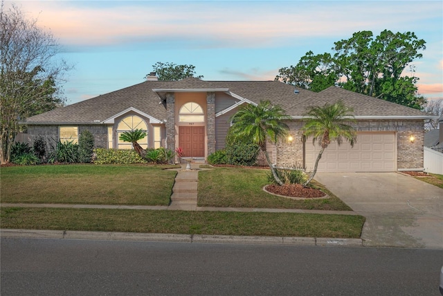 view of front of house with a garage, a chimney, concrete driveway, and a front yard