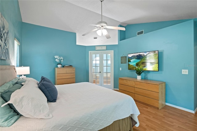 bedroom featuring visible vents, baseboards, lofted ceiling, french doors, and wood finished floors