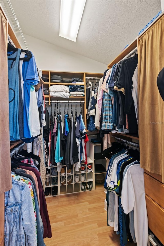 spacious closet featuring wood finished floors and vaulted ceiling