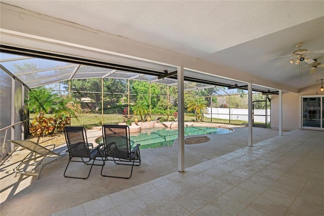 view of swimming pool featuring a fenced in pool, fence, glass enclosure, a patio area, and a ceiling fan