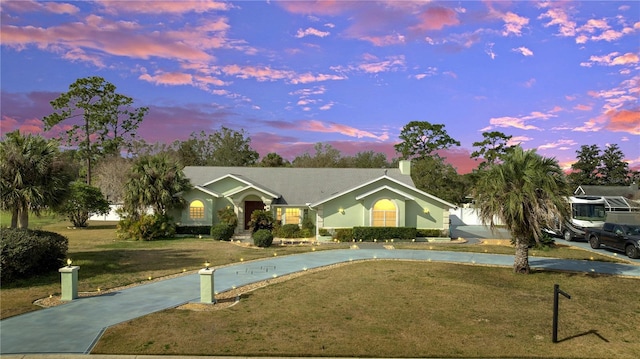 single story home featuring concrete driveway and a lawn